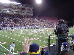 American football on the field with spectators in the stands.