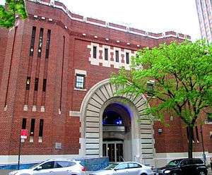 A brick building with a big central arched entrance