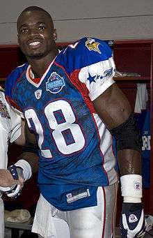 An American football player smiles. He is wearing a blue jersey with the number 28 across the chest.