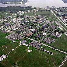 A large complex of buildings with a lake in the background