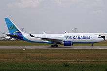 Side view of white twin-jet aircraft on airport runway.