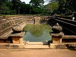A large rectangular artificial pond with carved stone sides.