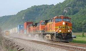 Orange locomotive hauling freight