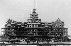 A black-and-white photograph of a grand beach-side hotel