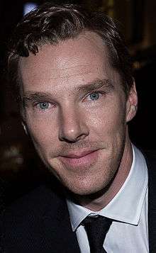Closeup of Benedict Cumberbatch in a white shirt and black tie facing the camera with brown hair