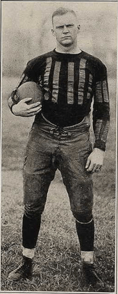 An unsmiling Bomar, holding a football