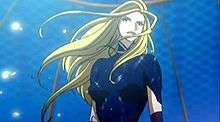 Anime of the upper bust of a young blond woman. She is wearing a body suit and gloves. Her hair is long and seems to be moving to the left.