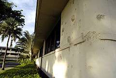 Photograph of the headquarters building at Hickam Field in 2005, still showing bullet and shrapnel damage to a wall.