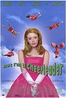 A half-length portrait of a young woman with long hair, wearing a bright pink formal dress and satin gloves. Behind her at a distance five cheerleaders in orange cheer-leading outfits perform cheer-leading maneuvers whilst falling through a bright blue sky. Across the portrait reads, in green, "But I'm a Cheerleader", and below, in smaller letters, "A Comedy of Sexual Disorientation". At the top of the picture, in small letters are the names "Natasha Lyonne, Clea Duvall, RuPaul Charles and Cathy Moriarty".