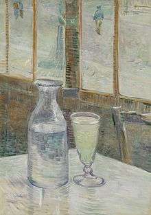 A glass and bottle on a cafe table