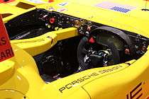 A view of the cockpit of a Porsche RS Spyder racing car showing the dashboard and steering wheel