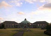 View of the front of Daldowie Crematorium and gardens at sunset