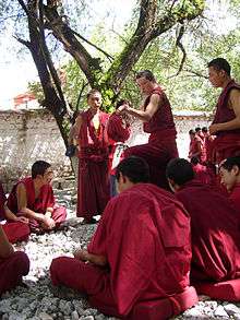monks wearing crimson robes debating at Sera Monastery, Tibet