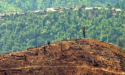 A deforested hill in front of a village.