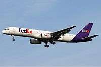 Side view of twin-jet aircraft in flight, showing "FedEx" lettering.