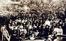 Large group of men in front of trees