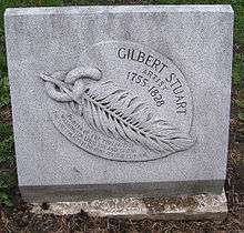 Marble plaque with an outlay of a feather linked to a piece of chain, and the name "Gilbert Stuart" carved on it.