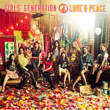 The cover art for the album. It portrays the girl group sitting, standing, or leaning against something in the corner of an art studio with paper flowers scattered on the floor. The peace symbol is plastered a few times on the image.