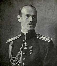 White male with classically-handsome features and a thin moustache wearing military uniform