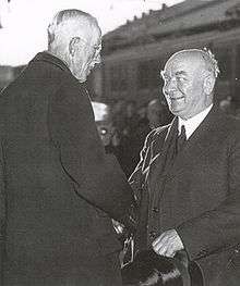 Two older men shaking hands