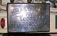 A rectangular plaque mounted on a bulkhead. The plaque reads "H.M.A.S. "Onslow". Engine no 798. Scotts' Shipbuilding & Engineering Co Ltd. Greenock. 1969"