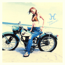 Ayumi Hamasaki wearing a swim top and jeans posing on a motorcycle on a beach.