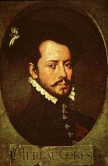 Old painting of a bearded young man facing slightly to the right. He is wearing a dark jacket with a high collar topped by a white ruff, with ornate buttons down the front. The painting is dark and set in an oval with the letters "HERNAN CORTES" in a rectangle underneath