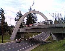 A MAX light rail train crossing the Main Street Bridge. The bridge is a tied concrete arch structure.
