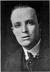 head and shoulders photograph of youngish balding man