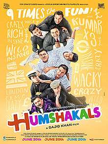 The image shows a human pyramid consisting of three men in matching suit coats above the same three men in matching casual shirts above the same three men in matching overcoats and hats against yellow background and the word "Humshakals" in multicolored letters.