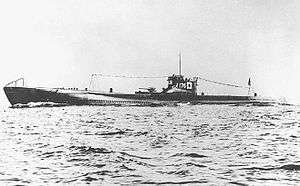 A large submarine underway. Japanese flags and the number "176" are painted on the fin.
