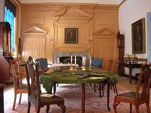 A room with large table and fireplace