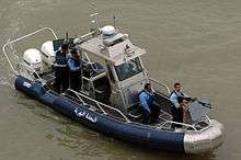 Boat with two motors, a machine gun and four police officers