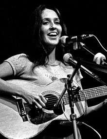 Black-and-white photograph of a woman with a guitar