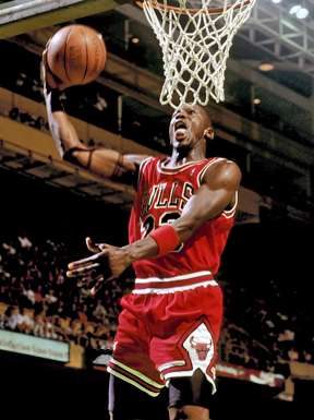 A basketball player, wearing a red jersey, is holding a basketball.