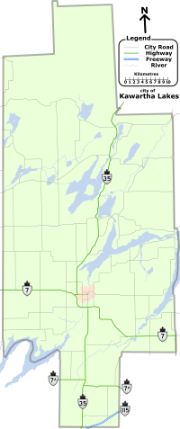 "A map of the entire City of Kawartha Lakes, outlined bya  grey line. The lakes, rivers, and roads of the region are shown. Lakes and rivers are dotted across the region and represented by blue shapes and lines. Kawartha Lakes is shaped like a cross which has been stretched vertically, and is approximately one quarter as wide as it is tall. For identification purposes, the remaining items are described in reference to the horizontal and vertical bar of the cross. Provincial highways, labelled, cross the map in several locations: Highway 35 bisects the entire map, travelling vertically from the bottom-centre to the upper-right along the vertical bar. Highway 7 crosses horizontally just below the mid-point from the left; After crossing Highway 35, it proceeds at an angle to the bottom right corner of the horizontal bar. Highway 7A is a straight and horizontal, bisecting the map below the horizontal arm of the cross. Highway 115, shown as two lines as it is a divided freeway, occupies a small space near the bottom-right corner of the vertical bar, crossing it at a forty-five degree angle up and to the right. The remaining black lines represent the numbered city roads."