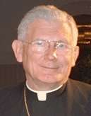 gray-haired man with glasses wearing clerical shirt and collar