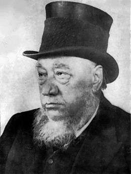 An old man with a grey beard and a black top hat