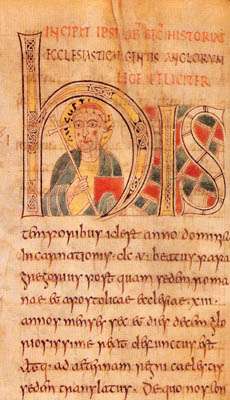 Illuminated manuscript with a forward-facing man in the middle of the large H. Man is carrying a crozier and his head is surrounded by a halo.