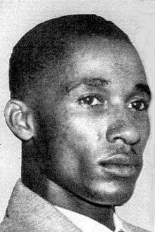 A black and white photograph of a young African American man with short hair in tight closeup.