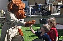 McGruff, left, high-fives two children at right