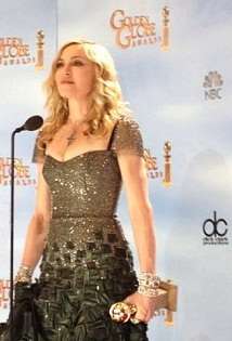 Madonna standing in front of a microphone holding an award