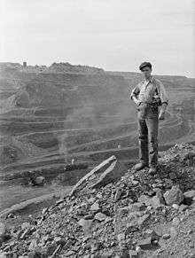 A miner poses near the edge of the pit. The pit is more than three miles long, two miles wide and 535 feet deep.