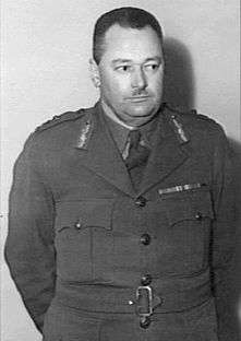 A black and white photograph of the upper body and head of a middle-aged Caucasian man. He is wearing the uniform of an Australian Army officer, has short dark hair and a small neatly cropped moustache on his upper lip.
