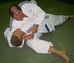 Judoka demonstrating kesa gatame variation
