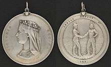 Photograph showing the two sides of a round silver medal, showing the profile of Queen Victoria on one side and the inscription "Victoria Regina", with the other side having a depiction of a man in European garb shaking hands with an Aboriginal in historic first nation clothing with the inscription "Indian Treaty 187"