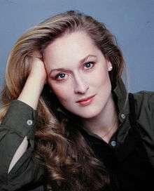 A headshot of Meryl Streep in the 1970s with her facing the camera with her right arm propping her head up