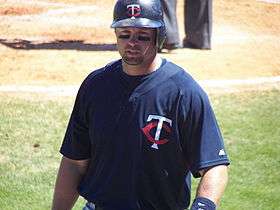 A man wearing eyeblack and a blue shirt with an interlocking "T" and "C" on the left breast.