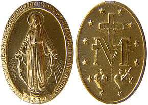 The image is of a small gold medallion with religious symbols carved on it.