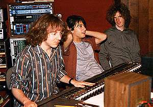 Mitch Easter sitting at a mixing board next to two musicians